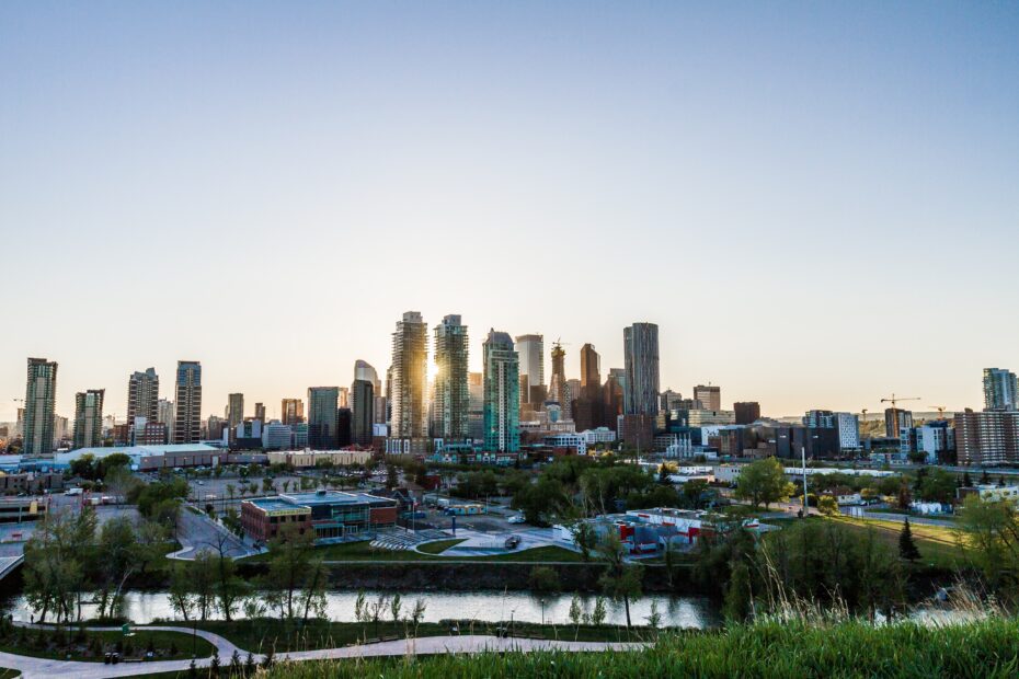 Stunning sunrise over Calgary, highlighting the Bow River with the downtown skyline illuminated in the morning light, emphasizing the city's vibrant real estate market.